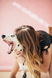 woman with long hair hugging dalmation